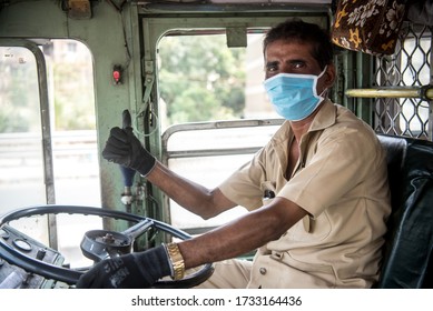 MUMBAI/INDIA - MAY 16, 2020: A Bus Driver Wearing Protective Mask And Gloves Gives The Thumbs-up During The COVID-19 Coronavirus Pandemic.