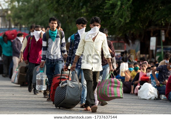 MUMBAI/INDIA - MAY 21, 2020: Migrant workers\
sits in queues at railway terminus for boarding a special train\
back home during a nationwide\
lockdown.