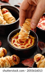 Mummy Dogs Dipped In Ketchup And Mustard Sauce, Close Up View. Halloween Funny Food Idea For Party