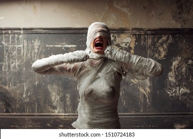 mummy screams in horror and tears the bandages. The girl with the bandage. Halloween