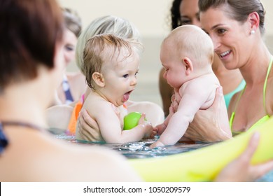 Mums being happy about their baby kids playing with each other in water