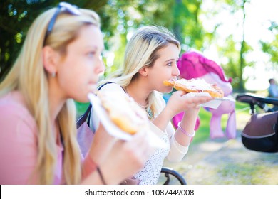 Mums Sit On A Bench And Eat Funnel Cakes In Park