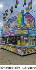 Muncie, Indiana - United States - 4-16-21 - Bright Carnival Food Booth With Flags And Overcast Sky