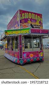 Muncie, Indiana - United States - 4-16-21 - Fuchsia Carnival Food Booth With Flags And Overcast Sky