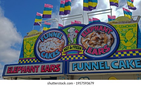 Muncie, Indiana - United States - 4-17-21 - Elephant Ears And Funnel Cake Signage On Carnival Food Stand With Flags