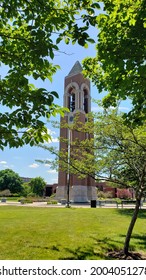 Muncie, Indiana - United States - 7-7-21: Ball State University Bell Tower Shot From Lawn Through Trees Withe Blue Skies 