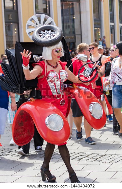 MUNICH, BAVARIA / GERMANY - JULY 14, 2018: A\
drag queen dressed up like a female red Volkswagen car attending\
the Gay Pride parade also known as Christopher Street Day (CSD) in\
Munich, Germany.