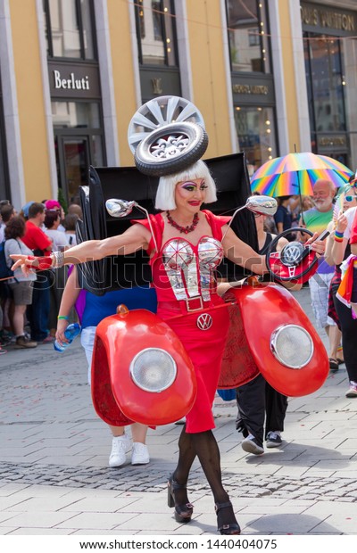 MUNICH, BAVARIA / GERMANY - JULY 14, 2018: A\
drag queen dressed up like a female red Volkswagen car attending\
the Gay Pride parade also known as Christopher Street Day (CSD) in\
Munich, Germany.