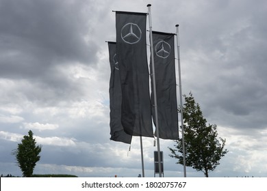 Munich, Bavaria/Germany - August 23, 2020: Flags With Mercedes-Benz Logo Beside A Car Dealer Building, Cloudy Sky. Mercedes-Benz Is A Global Auto Brand, A Division Of The German Company Daimler AG