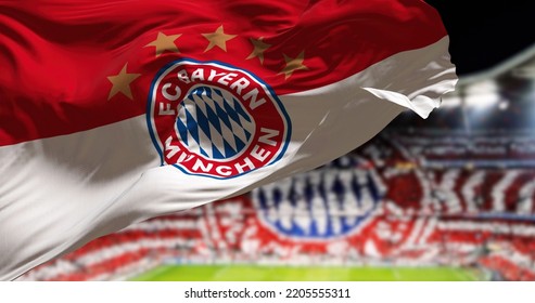 Munich, GER, May 2022: The Bayern Munich Flag Waving In The Wind With Allianz Arena Stadium Blurred In The Background. Bayern Munich Is A German Sports Club Based In Munich.