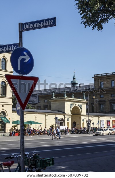 Munich, Germany - August 2, 2015: The Odeonsplatz in\
the inner city of Munich with its large square and unidentified\
people are passing by