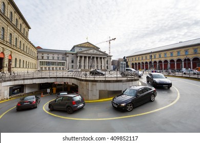 Munich, Germany - January 03 2016: The cars drives into the underground parking on the Odeon square on the background of Bavarian State Theater 