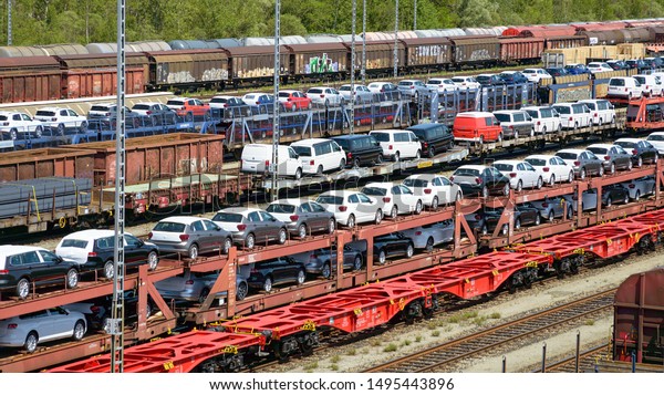 Munich, Germany - July 10, 2019: lots of new\
cars loaded on railway autorack wagons and ready for shipment from\
factories to automotive\
distributors