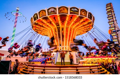 Munich, Germany - September 28: visitors, beertents and fairground rides on the oktoberfest in munich at September 28, 2019