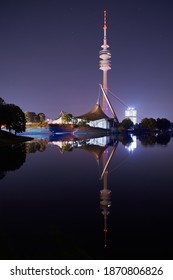 Munich-Bavaria-Germany - 09-09-2020: Skyline In Munich. Reflecting Lake In The Olympiapark In Munich At Night. Skyline Reflections In Munich.