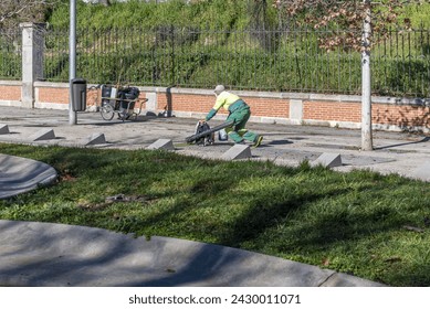 A municipal urban street cleaning employee preparing an air cannon to remove leaves