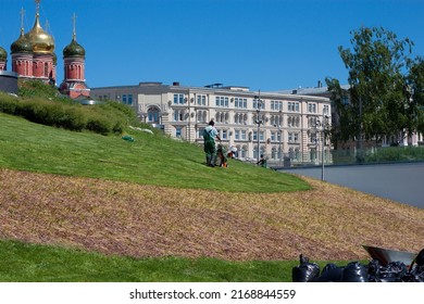 A Municipal Utility Worker, A Gardener Of The Municipality, Mows The Grass In The City Park. June 7, Moscow, Zaryadye Park