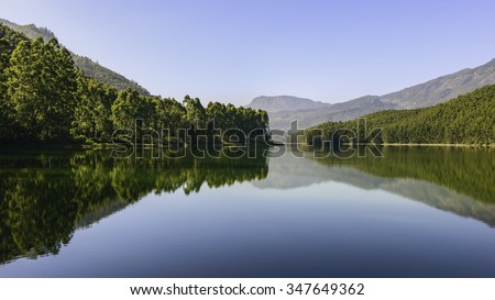 Munnar, Kerala, India. Echo point, a natural lake and reservoir flanked by forest and the Kannan Deven hills in the background on a fine winter morning near Munnar, Kerala, India.