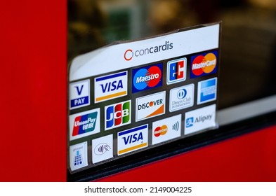 Munster, Germany - April 18, 2022: Various payment options, Discover, JCB, UnionPay, Mastercard, Diners Club International, VISA and Alipay, are seen on the door sticker in a store.