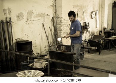 Murano Island, Italy - April 23, 2017: Glassblowing Artisan At Work In A Crystal Glass Workshop In Murano, Venice. Glassmakers Use The Same Tools As Their Ancestors Have Thousands Of Years Ago.