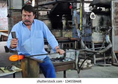 MURANO ISLAND - MAY 01 2011:Glassblowing Artisan At Work In A Crystal Glass Workshop In Murano Island Venice Italy.Murano Glassmakers Use The Same Tools As Their Ancestors Have Thousands Of Years Ago