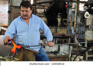 MURANO ISLAND - MAY 01 2011:Glassblowing Artisan At Work In A Crystal Glass Workshop In Murano Island Venice Italy.Murano Glassmakers Use The Same Tools As Their Ancestors Have Thousands Of Years Ago