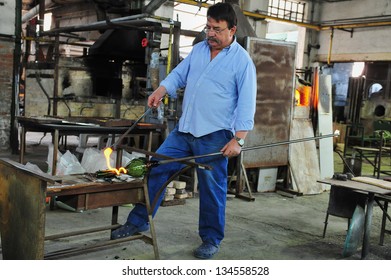 MURANO ISLAND - MAY 01 2011:Glassblowing Artisan At Work In A Crystal Glass Workshop In Murano Island Venice Italy.Murano Glassmakers Use The Same Tools As Their Ancestors Have Thousands Of Years Ago