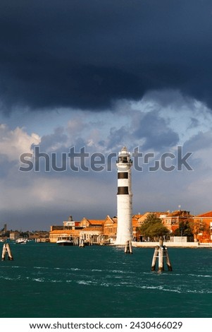 Murano Lighthouse or Faro di Murano is active lighthouse located on Murano island, Venice, Italy, in Venetian Lagoon on Adriatic Sea. View from water bus with dark blue stormy sky in background. Foto stock © 