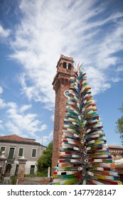 Murano ,Venice - 05/31/19 : Glass Tree Sculpture And Tall Clock Tower In Murano ,Venice,Italy.