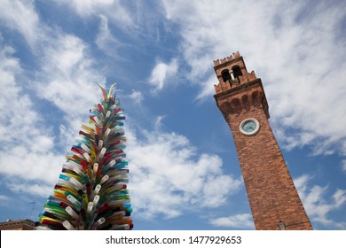 Murano,Venice,Italy - 05/31/19 - Glass Tree Sculpture And Tall Clock Tower In Murano ,Venice,Italy.