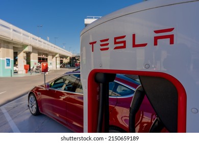 MURCIA, SPAIN - FEBRUARY 2, 2021: A red Tesla Model 3 is parked in a Supercharger station in a mall of Murcia, Spain. This station has 10 Superchargers, available always and up to 150 kW