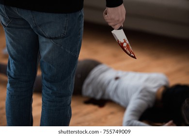 Murder, Kill And People Concept - Criminal Or Murderer With Knife In Blood And Dead Woman Body Lying On Floor At Crime Scene