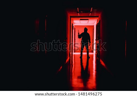murder, kill and people concept - Criminal or murderer wearing a mask in silhouette holding knife inside a condo at crime scene
