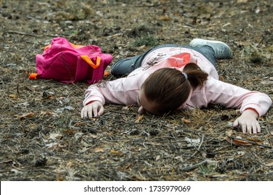 Murder in the woods.The body of a teenage girl in a tracksuit lies on the ground in the woods. Victim of violence. The concept of child abduction. Horizontal photo. Close up.