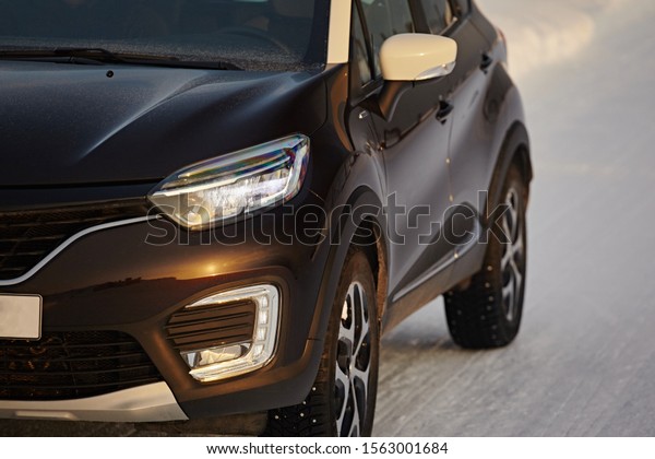 Murmansk Region, Russia - March 2018:   A\
fragment of the front of a modern car Renault Captur with\
headlights, bumper, fog lamp close-up on the\
snow.
