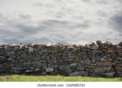 Muro De Piedra Con Cielo Nublado Gris