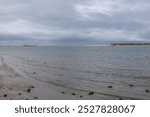 The Murray River mouth with a permanent dredger keeping it open, as seen from the shore of Hindmarsh Island under an overcast, cloudy sky in the Coorong area on the Fleurieu Peninsula, South Australia