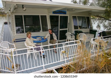 Murray River, South Austraila - Jun 5 2006: A Middle Age Couple Enjoy A Drink On The Front Deck Of A Houseboat. Houseboat Holidays Are Very Popular In Australia.