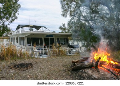 Murray River, South Austraila - Jun 5 2006: A Middle Age Couple Enjoy A Drink On The Front Deck Of A Houseboat. Houseboat Holidays Are Very Popular In Australia.