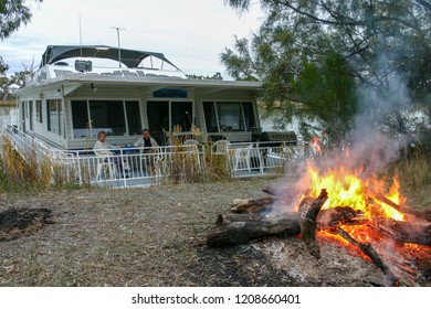 Murray River, South Austraila - Jun 5 2006: A Middle Age Couple Enjoy A Drink On The Front Deck Of A Houseboat. Houseboat Holidays Are Very Popular In Australia.