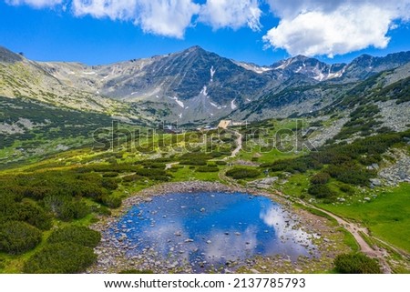 Musala peak mirroring at a surface of a mountain lake in bulgaria