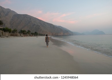 MUSANDAM, OMAN - NOVEMBER 20, 2016: Tourist walking along the beach at Zighy Bay in the Omani enclave of Musandam