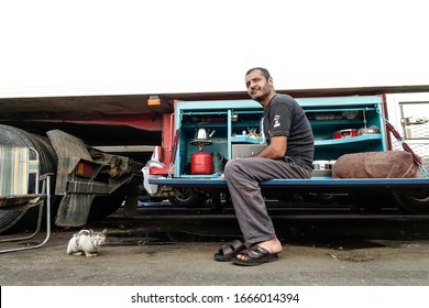 Muscat, Oman Feb 2, 2020 A Jordanian Trucker Eating In His Truck Kitchen And A Stray Cat.