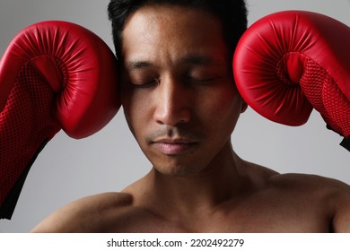 Muscle Asian Boxer Man With Closed Eyes Red Gloves Posing Indoor. Mock-up.