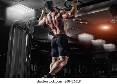 Muscle Athlete Man In Gym Making Elevations. Bodybuilder Training In Gym