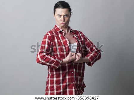 muscle concept - strong 40s woman with fists tight together sticking out chest showing her courage,studio shot