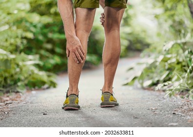 Muscle Pain Sports Injury Runner Man Touch Leg Calf In Pain. Painful Legs Athlete Massaging Sore Calf Muscles During Running Training Outdoor.