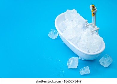 Muscle recovery and healing therapy, performance improvement treatment and extreme cold cryotherapy concept with minimalist bathtub filled with ice isolated on blue background with copy space