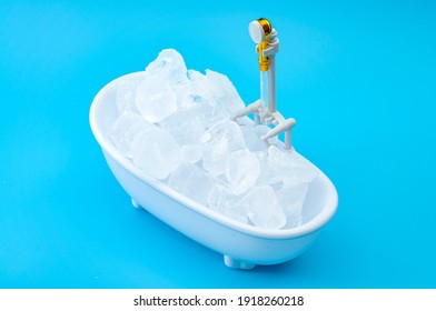 Muscle recovery and healing therapy, performance improvement treatment and extreme cold cryotherapy concept with minimalist bathtub filled with ice isolated on blue background