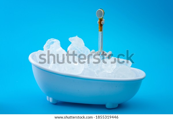 Muscle recovery and\
healing therapy, performance improvement treatment and extreme cold\
cryotherapy concept with minimalist bathtub filled with ice\
isolated on blue\
background